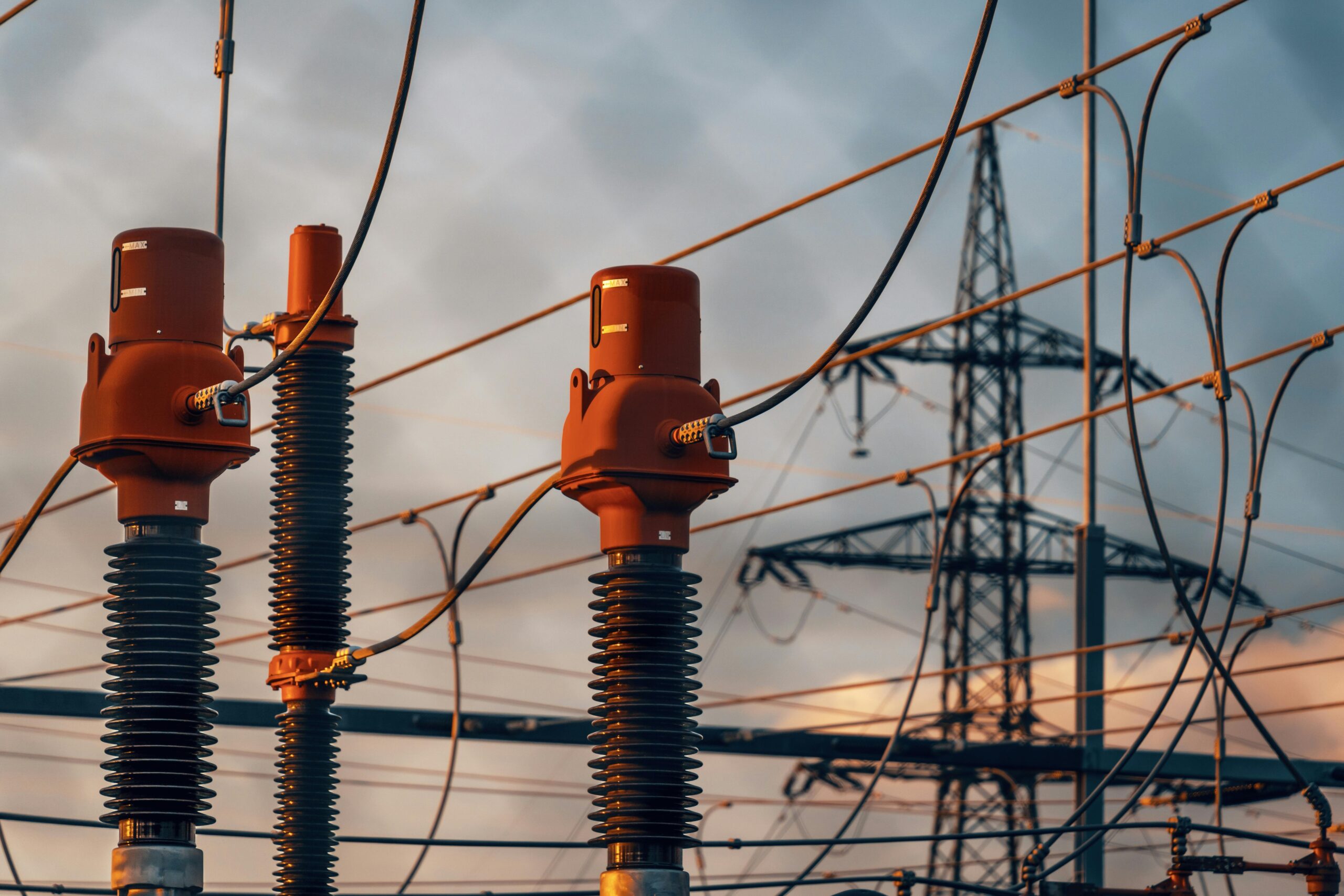 Home Detailed view of power transformers and lines against a sunset sky in Austria.